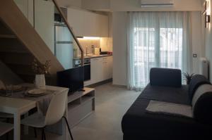 a living room with a couch and a table and a kitchen at AK Luxury Lofts in Ioannina