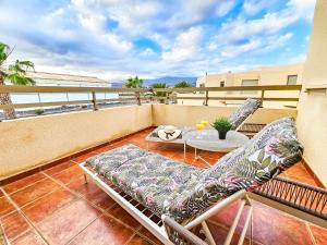 a balcony with two chairs and a table on a roof at La Tejita - Family Apartment Home in La Mareta