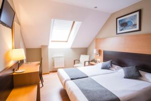 ein Hotelzimmer mit Bett und Fernseher in der Unterkunft Alda Barraña Playa in Boiro