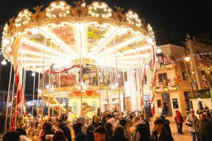 a crowd of people standing in front of a carousel at Apartament City Center Craiova in Craiova