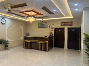 a waiting room with a desk and a clock on the wall at Hotel new royal palace in Lahore