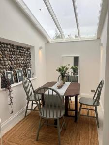 d'une salle à manger avec une table, des chaises et une lucarne. dans l'établissement Seaside Retreat - Sleeps 5 garden & parking, à Cromer