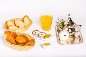 a table with two baskets of bread and orange juice at JEMAA EL FNA Suites & Spa in Marrakesh