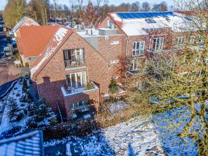 una vista aérea de una casa de ladrillo en la nieve en Ferienwohnung Küstenhaus, en Esens