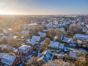 Una vista aérea de un pueblo con techos cubiertos de nieve. en Ferienwohnung Küstenhaus, en Esens