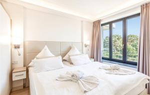 a bedroom with a white bed with two bows on it at Princess in Binz +36 photos