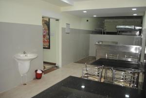 a kitchen with chairs and a sink in a room at SSR Hotel in Srikalahasti