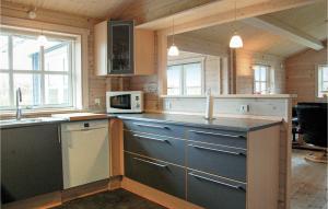 a kitchen with blue cabinets and a counter top at Holiday Home Løjtnantvænget Denmark X in Spodsbjerg