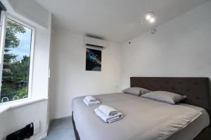 een slaapkamer met een groot bed met handdoeken erop bij Stratum Apartment No Kitchen - By T&S in Eindhoven