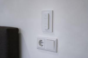 twee witte schakelaars op een witte muur bij Stratum Apartment No Kitchen - By T&S in Eindhoven