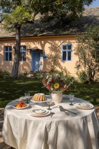 a table with a white table cloth on it in front of a house at Čuružanka in Čurug