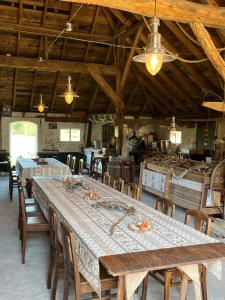 a dining room with a long table and chairs at Erve Zonnehoeve B&B en Wijngaard in Vorden