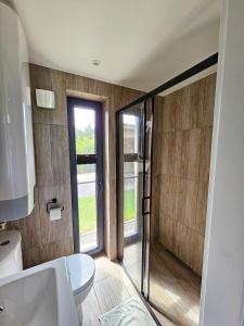 a bathroom with a toilet and a glass shower at Hytte Na Wyspie -,,Roztoczańskie Morze'' in Kulików +102 photos
