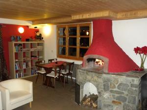 a fireplace in a living room with a table and a dining room at Hotel Restaurant Walliser Sonne in Reckingen - Gluringen
