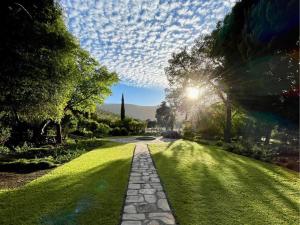 a stone path in a park with the sun shining at Grey Ghost Lodge in Cradock