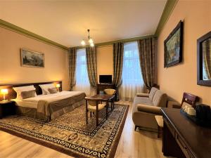a hotel room with a bed and a couch at Pałac Henryków in Szprotawa +59 photos