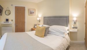 a bedroom with a bed with white sheets and pillows at Waterfront House in Dartmouth