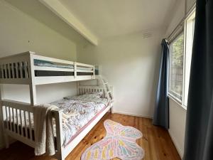 a small bedroom with a bunk bed and a window at Rye Holiday Getaway BYO Linen and Towels 750m walk to Beach in Rye