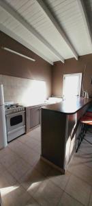 a large kitchen with a stove and a counter top at Duplex en Necochea in Necochea