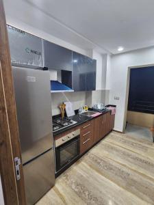 een keuken met een koelkast en een fornuis bovenste oven bij Évasion élégante à Marrakech in Marrakesh