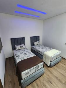 twee bedden in een kamer met een blauw plafond bij Évasion élégante à Marrakech in Marrakesh