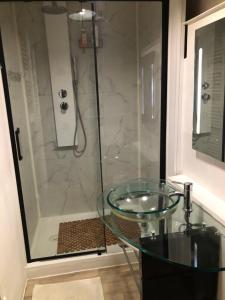 a bathroom with a glass sink and a shower at Le Victor HUGO 1G et sa pizza offerte in Aurillac