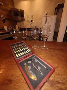 a table with wine glasses and a tray with a remote control at Suite Deluxe Aconchegante com Jacuzzi Bingen Petrópolis in Petrópolis