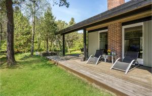 a deck with two chairs and a table on a house at Holiday Home Skovvang Nørre Nebel Iii in Lønne Hede