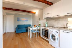 a kitchen with a washer and dryer and a table at Your Sea Escape in Riva Trigoso