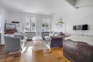 a bedroom with a bed and chairs and a tv at Dohlenhof Das Scheunentor in Keitum