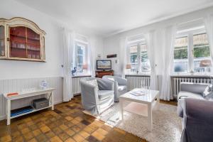 a living room with white furniture and windows at Dohlenhof Das Scheunentor in Keitum