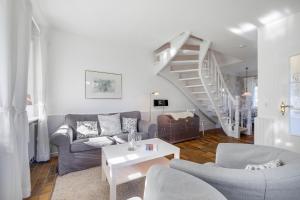 a living room with a couch and a staircase at Dohlenhof Das Scheunentor in Keitum +15 photos
