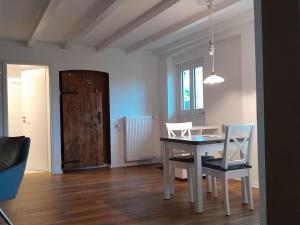comedor con mesa, sillas y puerta en Gästehaus Siebengebirge, en Königswinter 13 fotos más