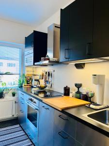 a kitchen with blue cabinets and a wooden counter top at Cozy Condo in Käpylä in Helsinki