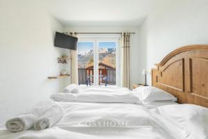 A bed or beds in a room at Chalet des Alpes - Sunset View - Crans-Montana