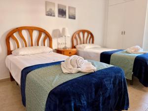 a room with two beds and a towel on a table at Kingfisher Apartments Benal Beach in Benalmádena +62 photos