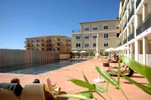 a group of people sitting around a pool in a building at Le T2 Green, 4 pers, clim, piscine, parking in Juvignac
