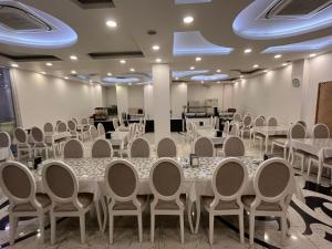 a banquet hall with white tables and chairs at Garra Hotel in Konya