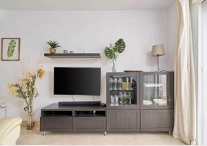 ein Wohnzimmer mit einem Entertainment-Center mit Flachbildfernseher in der Unterkunft Apartamento Alcazar in Almuñécar
