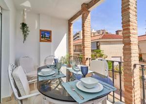 ein Esszimmer mit Tisch und Stühlen auf einem Balkon in der Unterkunft Apartamento Alcazar in Almuñécar