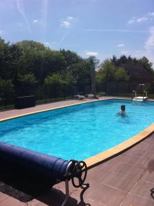 a man swimming in a swimming pool at Gîte du Roi Morvan in Ploërdut