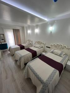 a hotel room with four beds in it at Garra Hotel in Konya