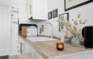 a kitchen counter with a vase of flowers on it at Beautiful Apartment In Nexø in Neksø +12 photos
