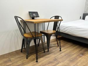 ein Schreibtisch mit zwei Stühlen und einem Bett in der Unterkunft THE BEDROOM Daimyo in Fukuoka