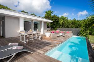a patio with a table and a swimming pool at Jardin d'O résidence naturiste couples only in Cul de Sac