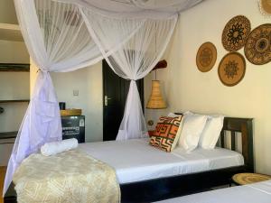 a bedroom with a bed with white curtains at Shela Bliss in Lamu