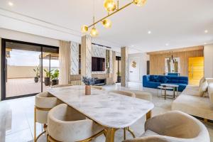 a living room with a table and chairs at Villa de plain-pied avec piscine chauffée à Marrakech in Marrakech