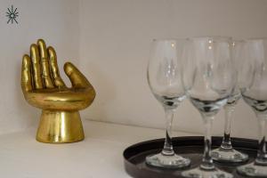 a gold hand is sitting between four wine glasses at Nido Madreperla in Taranto +12 photos