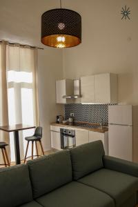 a living room with a green couch in a kitchen at Nido Madreperla in Taranto