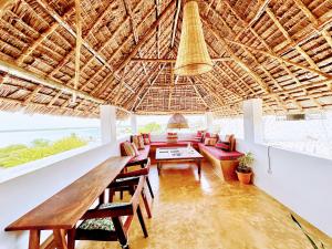 a dining room with a wooden table and chairs at Shela Bliss in Lamu